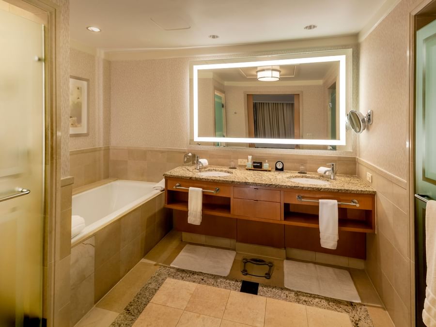 Bathroom bathtub by the illuminated vanity mirror in Spa Level Suite at The Umstead Hotel and Spa