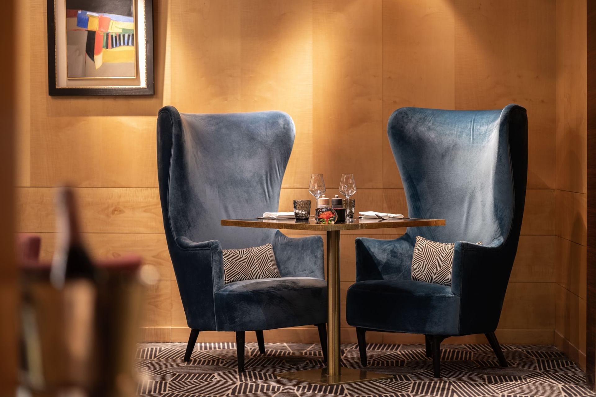 Blue wingback chairs by a set dining table at Restaurant, Bar & Terrace Le W, one of the best bars near Champs-Élysées