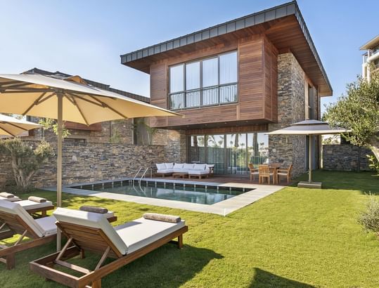 Sun loungers by the outdoor pool area & wooden sunbeds of the Exclusive Villa at Cullinan Belek