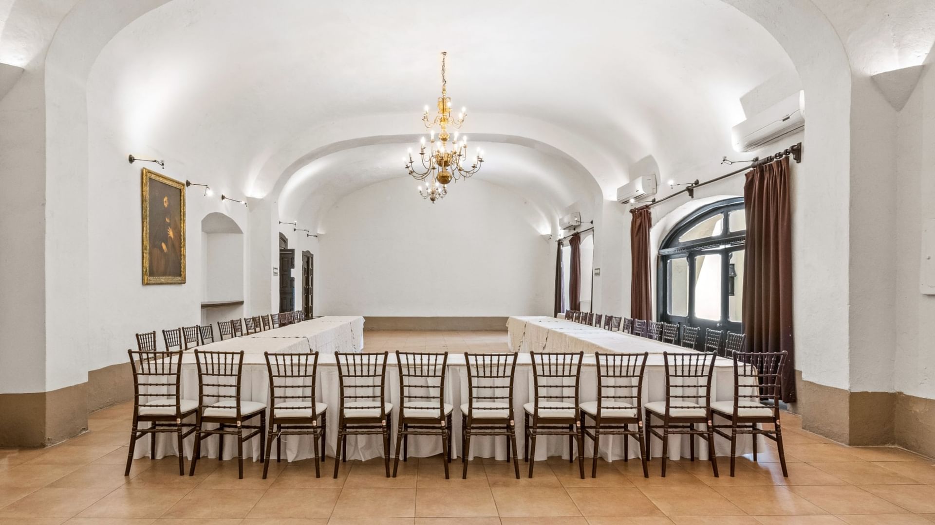 Long banquet table with chairs in the 5 de Mayo event room at Quinta Real Puebla in Heroica Puebla de Zaragoza.