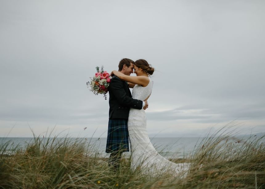 Married couple posing by the ocean with a scenic view at Ogunquit River Inn