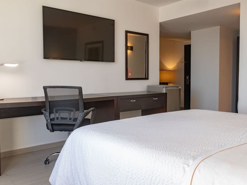 Prime Suite with working area TV, wall mirror and bed at Fiesta Inn