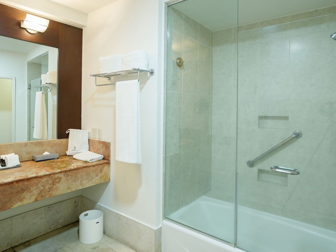 King Junior Suite glass shower and marble vanity equipped with fresh towels and safety grab bars at Camino Real Pachuca
