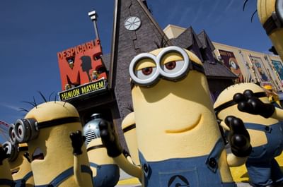 Minion character statues in blue overalls standing by the Despicable Me sign near Galleria Palms Hotel 
