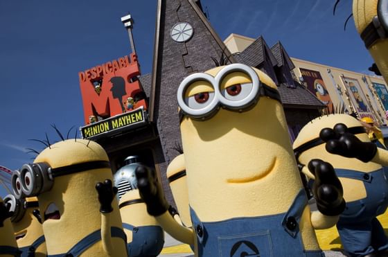 Minion character statues in blue overalls standing by the Despicable Me sign near Galleria Palms Hotel 