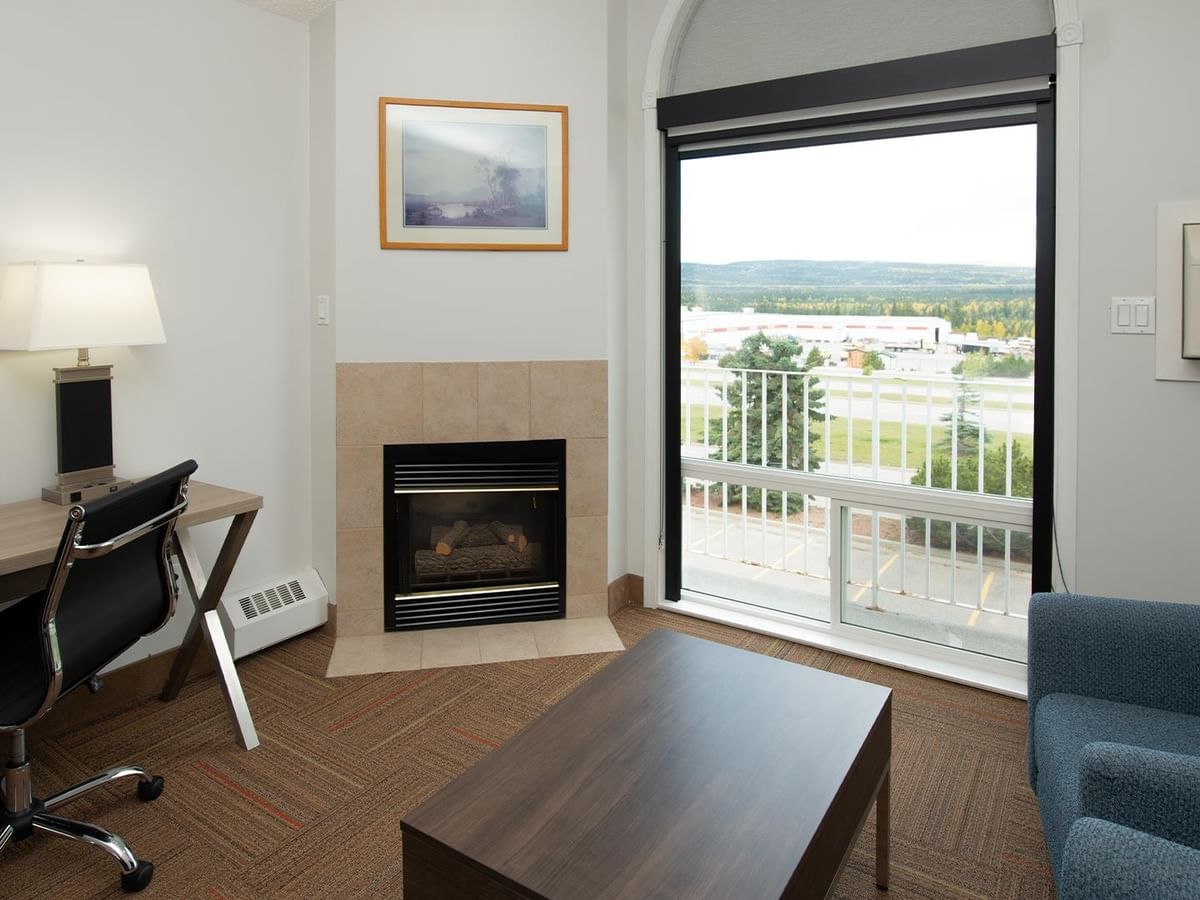 Coast King room with fireplace, work desk, and balcony overlooking mountain views.