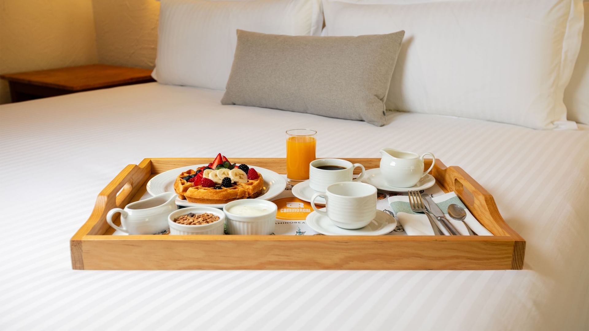 Tray with breakfast on a bed at Camino Real Guadalajara in Zapopan