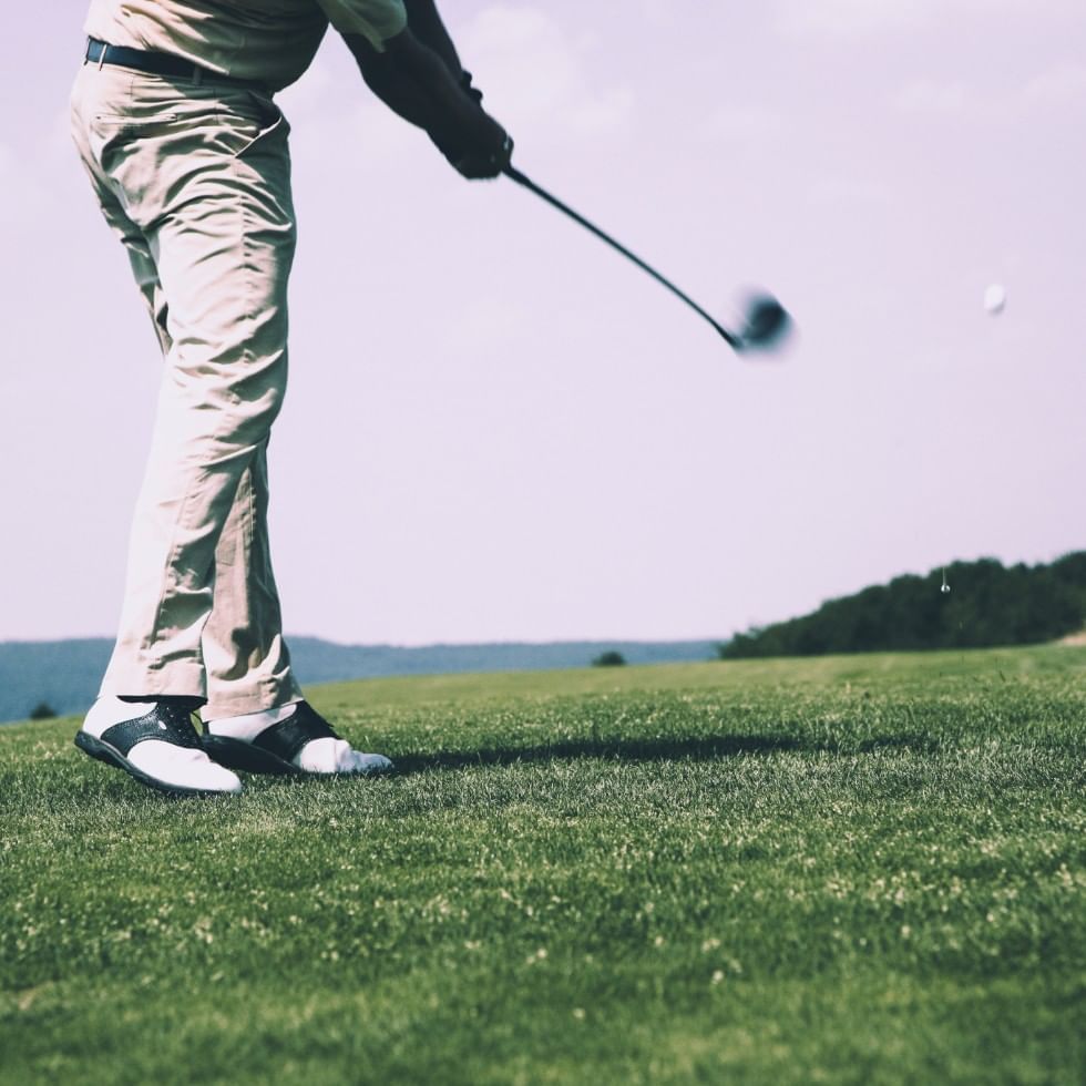 Golf player hitting the ball at Falkensteiner Hotels