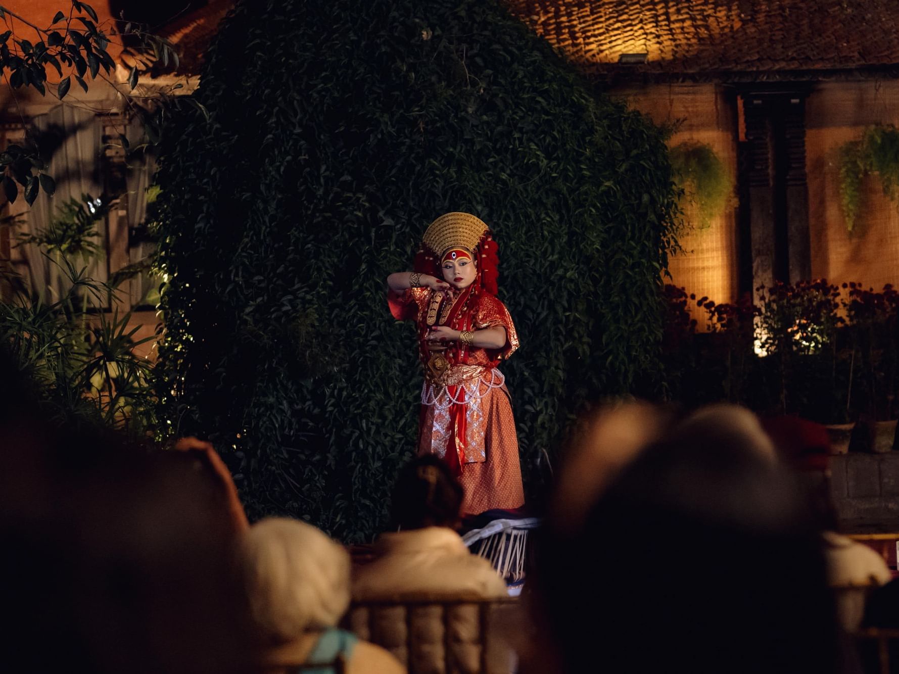 Lady in traditional red attire captivates an audience in Concert at Courtyard near Dwarika's Hotel Kathmandu