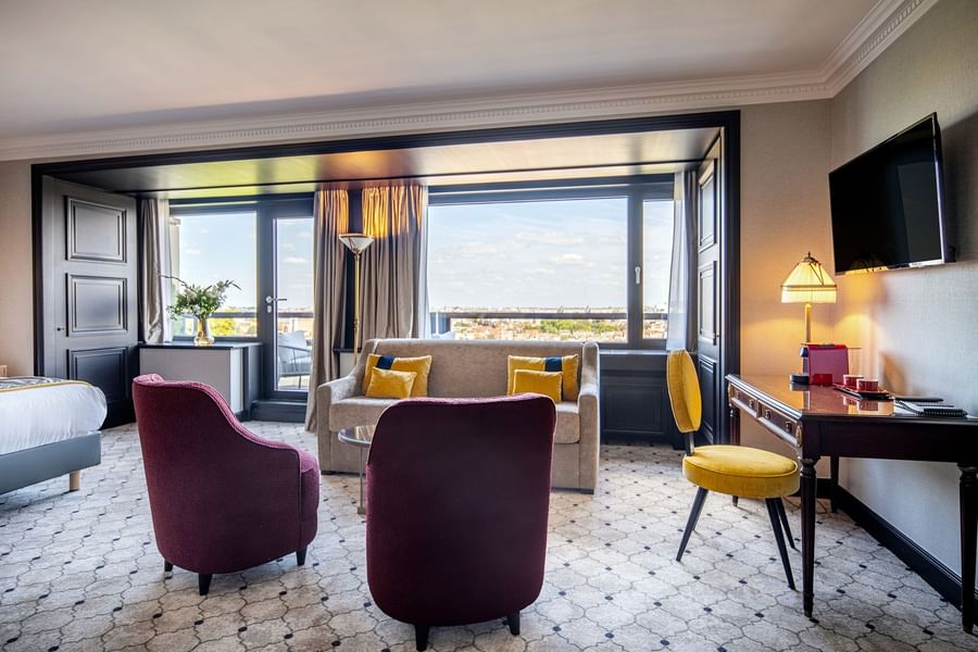 Living area with two purple armchairs & yellow desk chair by city view in Junior Suite at Hotel Barsey by Warwick