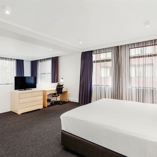 King bed and work area in Mercure Superior One-Bedroom Lakeview Suite at Pullman Albert Park