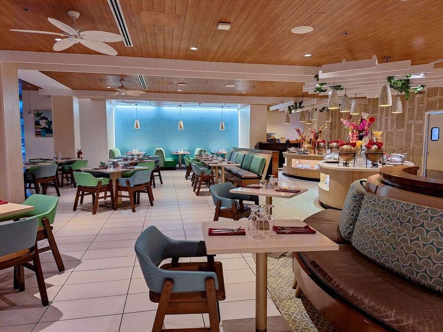 Elegant dining area with colorful chairs by a buffet station in Verandah at Warwick Paradise Island Bahamas