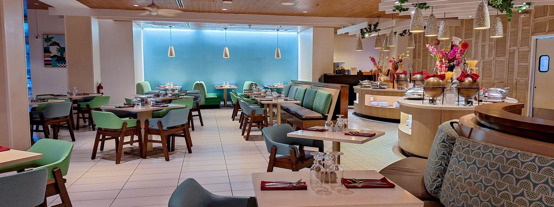 Verandah restaurant interior with  Dining tables by a buffet under stone pendants at Warwick Paradise Island Bahamas