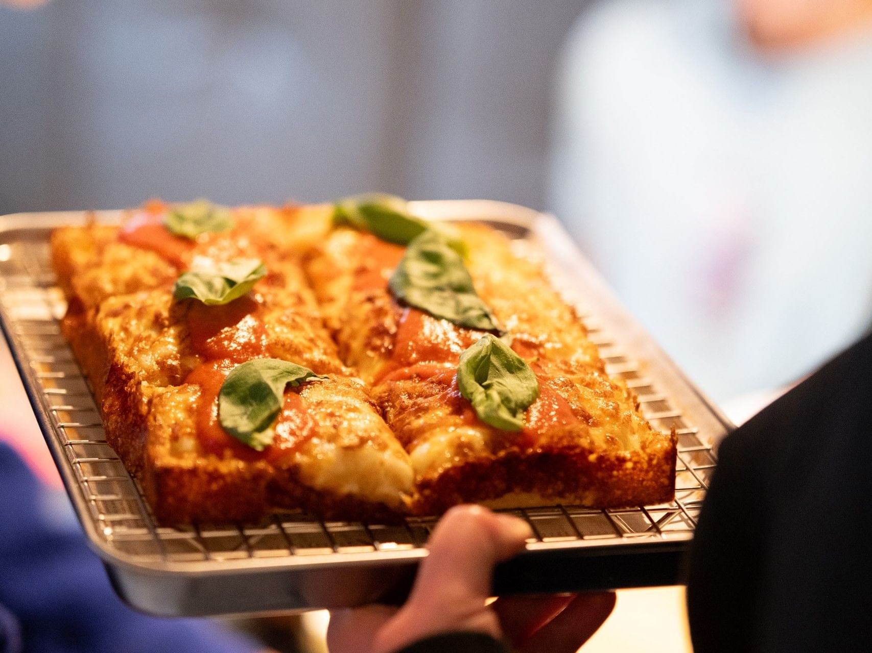 Deep-dish square pizza with melted cheese, tomato sauce, and fresh basil served at Sandman Signature Sheffield Quays Hotel