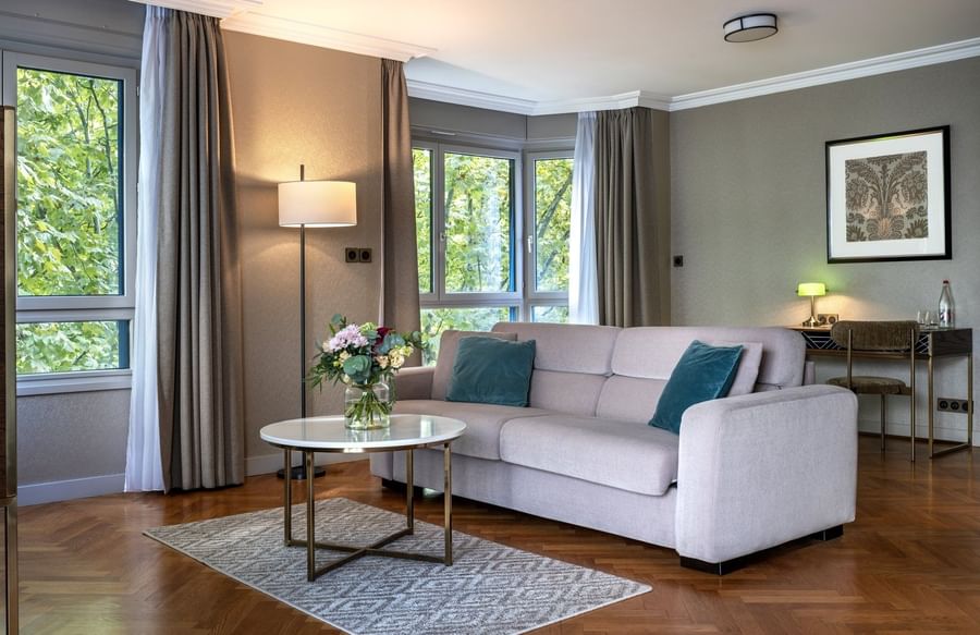 Work desk by the living area with plush seating & a lush greenery view in the Executive Suite at Warwick Reine Astrid - Lyon