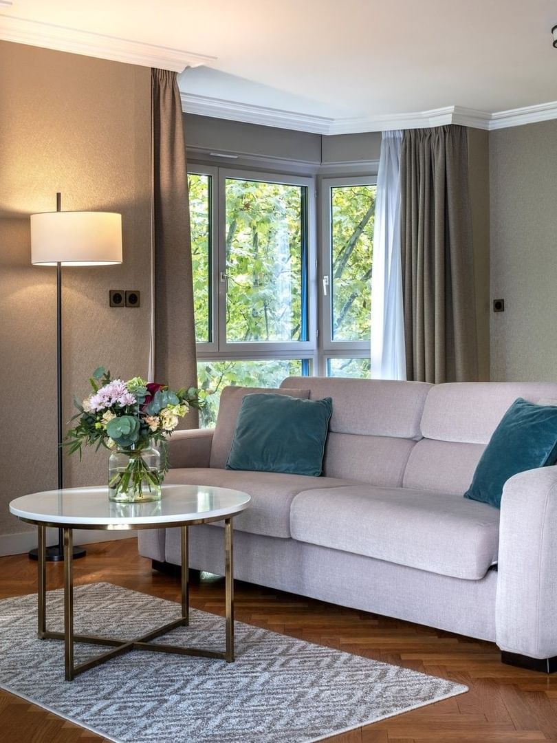 Work desk by the living area of Executive Suite with a lush greenery view and wooden floors at Warwick Reine Astrid - Lyon