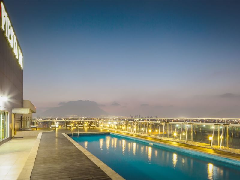 Rooftop swimming pool with warm lighting at Fiesta Inn