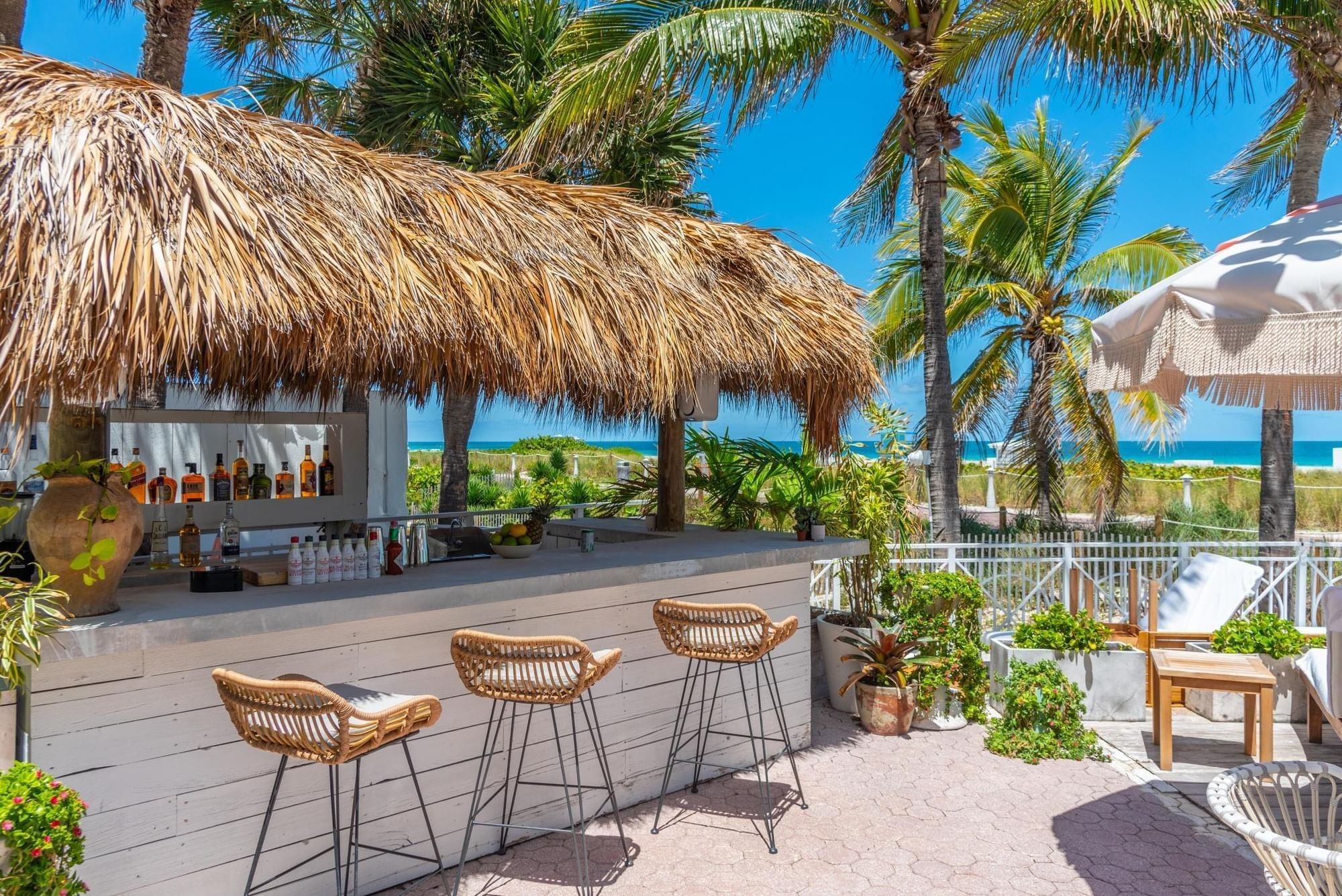 A thatched roof bar with a view of the ocean