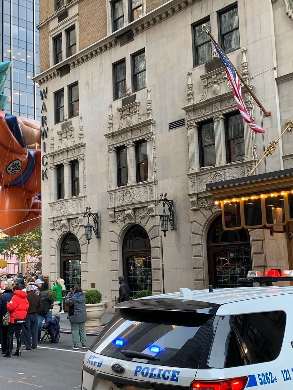 Goku balloon flying by the Warwick Hotel under a clear sky during a city parade near Warwick Hotels & Resort