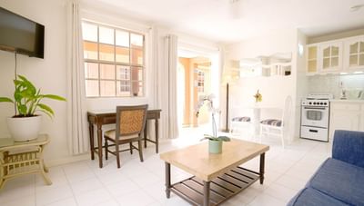 Light living space with a blue sofa and dining area beside a modern, fully equipped kitchen at Worthing Court Apartment