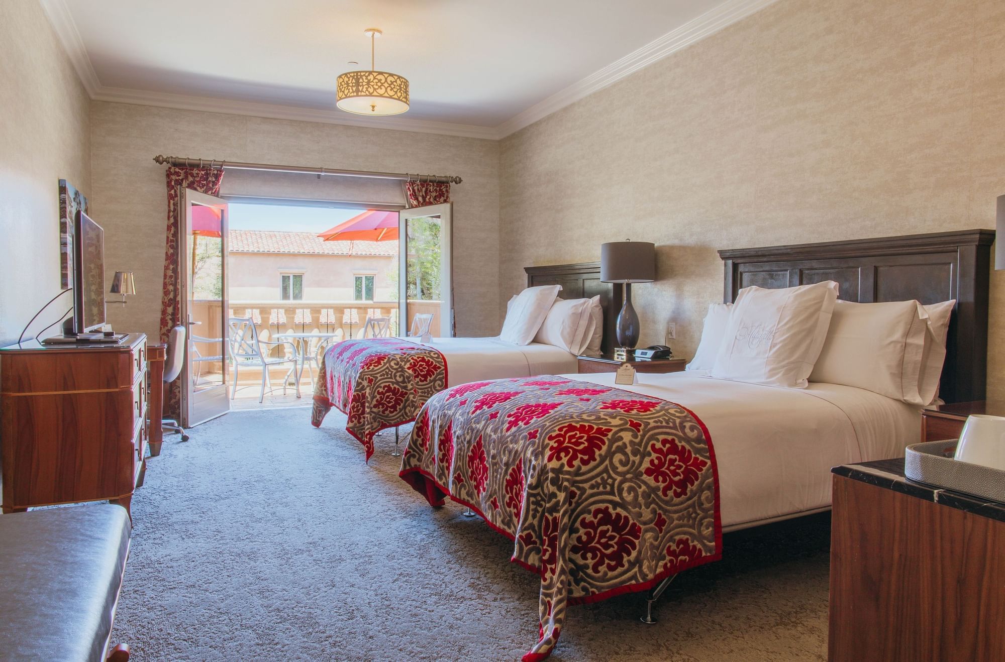 Lorem ipsum Hotel guest room with two queen sized beds and patio doors open