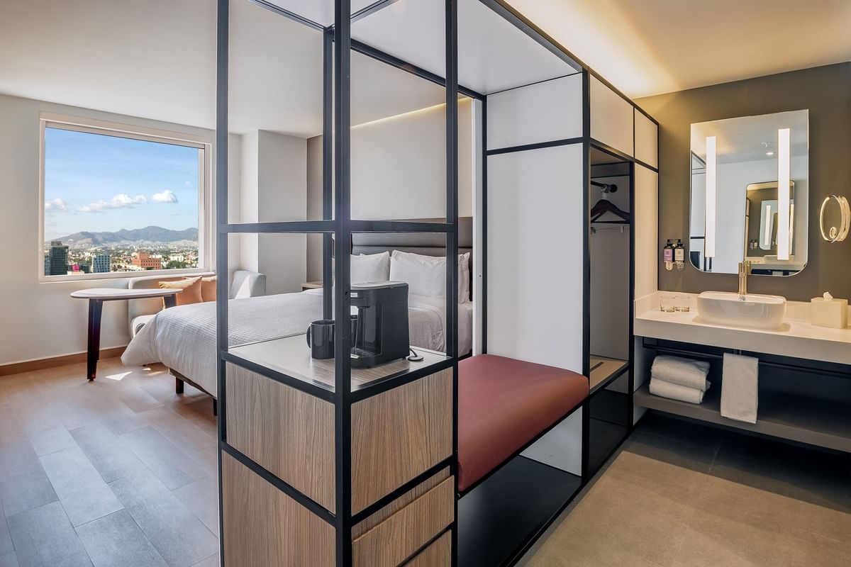 Habitación elegante con baño abierto y cama con ventana grande y vista en Fiesta Inn