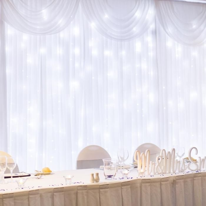 Elegant wedding reception table with Mr & Mrs Smith signage and a sparkling backdrop at Mercure Hotel Townsville