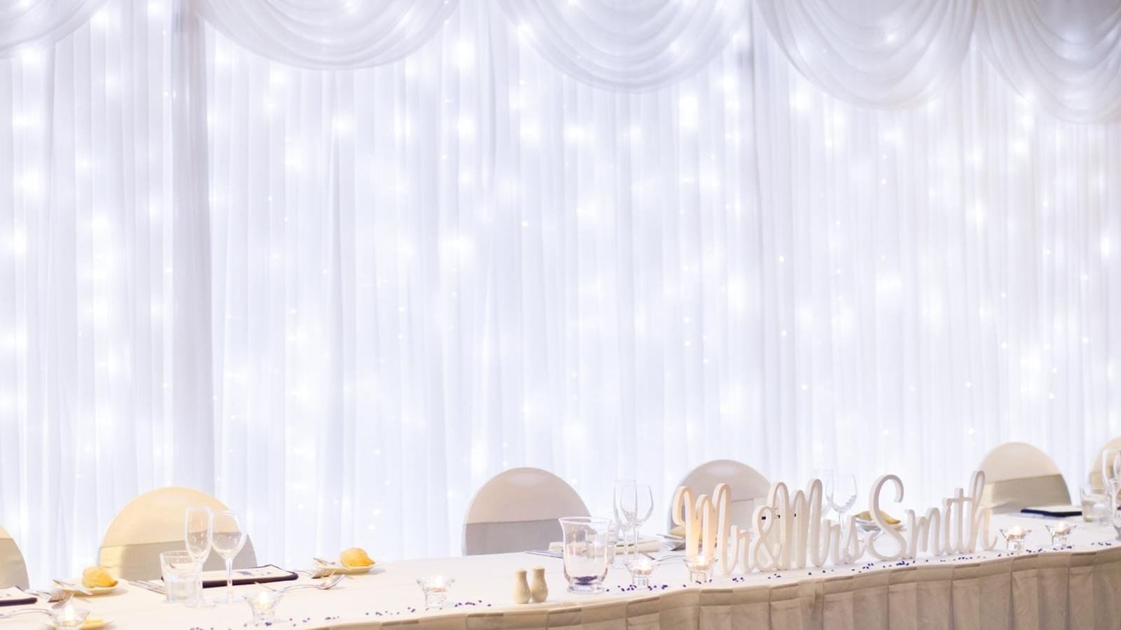 Elegant wedding reception table with Mr & Mrs Smith signage and a sparkling backdrop at Mercure Hotel Townsville