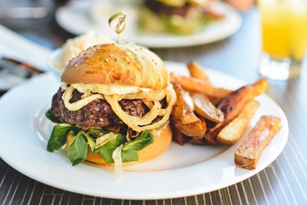 Burger with chips served in Magical Dining Month near Lake Buena Vista Resort Village & Spa