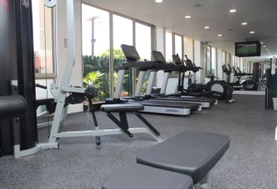 Interior of the fitness center with gym equipment at Courtleigh Hotel & Suites