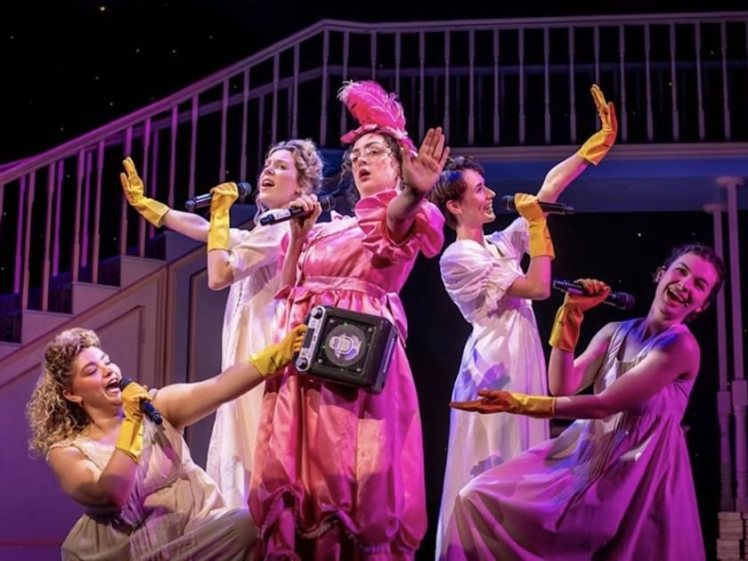Performers in period costumes with yellow gloves act on stage in Pride and Prejudice* (*sort of)