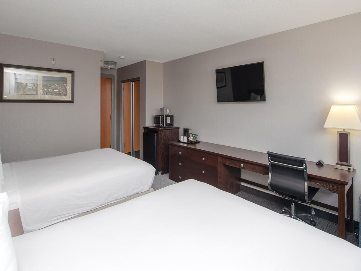 Two queen beds room with desk and chair.