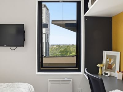 Modern room with a desk and city view at UniLodge Auckland City.