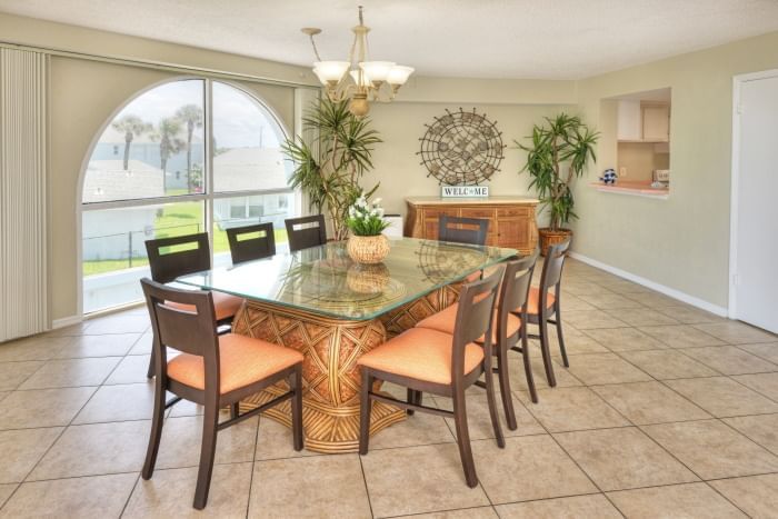 A wide view of a dining room with a large table and chairs.
