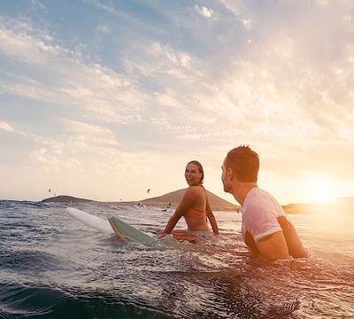 A couple surfing in the beach at Mundo Imperial