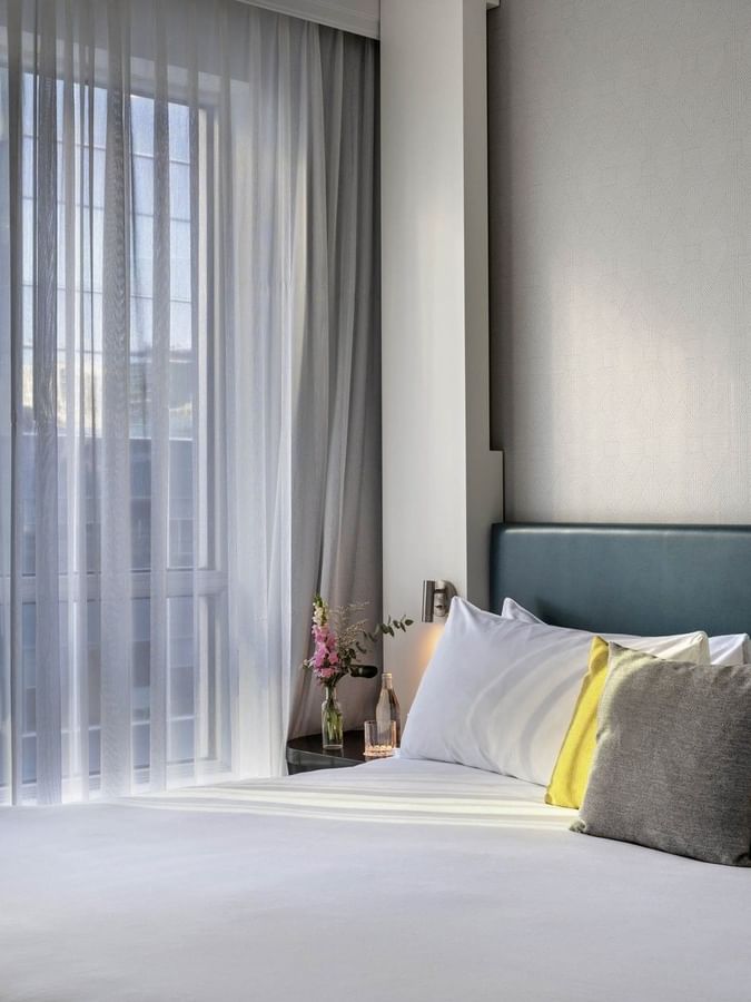 Chambre « Cozy Crystal Suite » avec un grand lit, une décoration élégante et une vue sur la ville au Warwick Le Crystal Montréal.