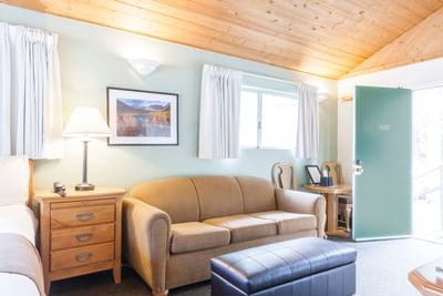 Room with bed, nightstand and cozy sofa at Alpenhof Lodge