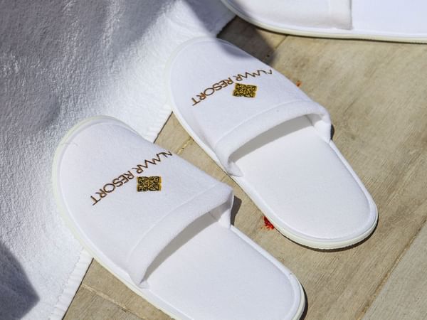 Close-up of white slippers with hotel branding at Almar Beach Resort