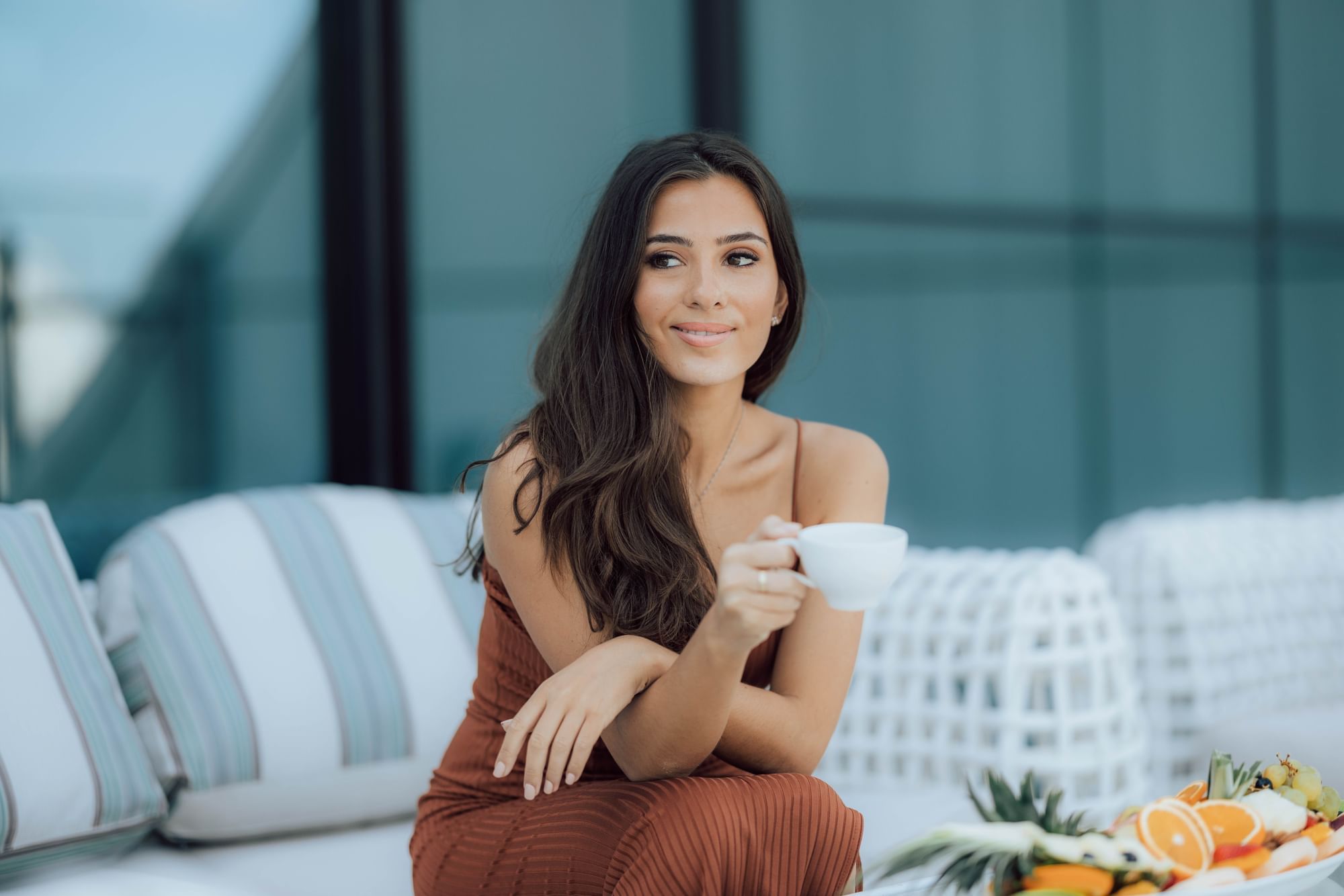 A woman having tea in lounge area on the rooftop at Maison Royale The Distinction