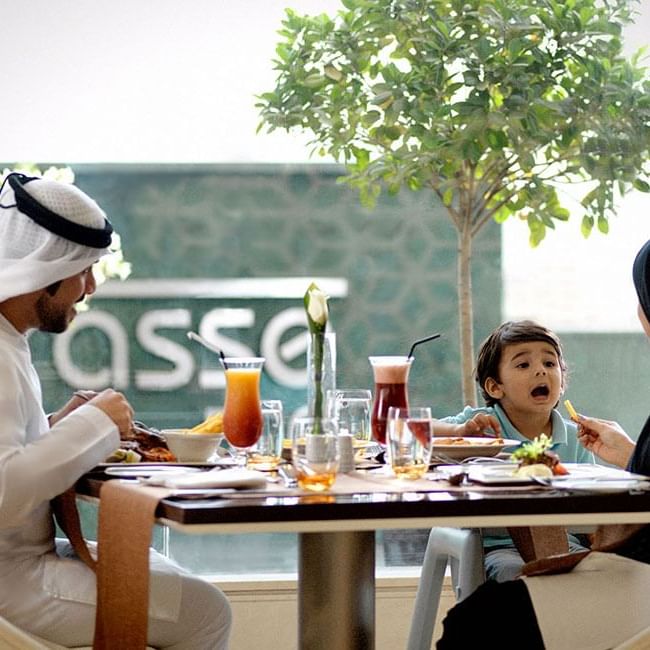 A family dining at a table at Two Seasons Hotel & Apt