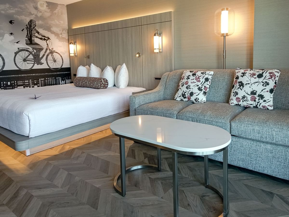 Hotel guestroom with king bed, sofa and coffee table.
