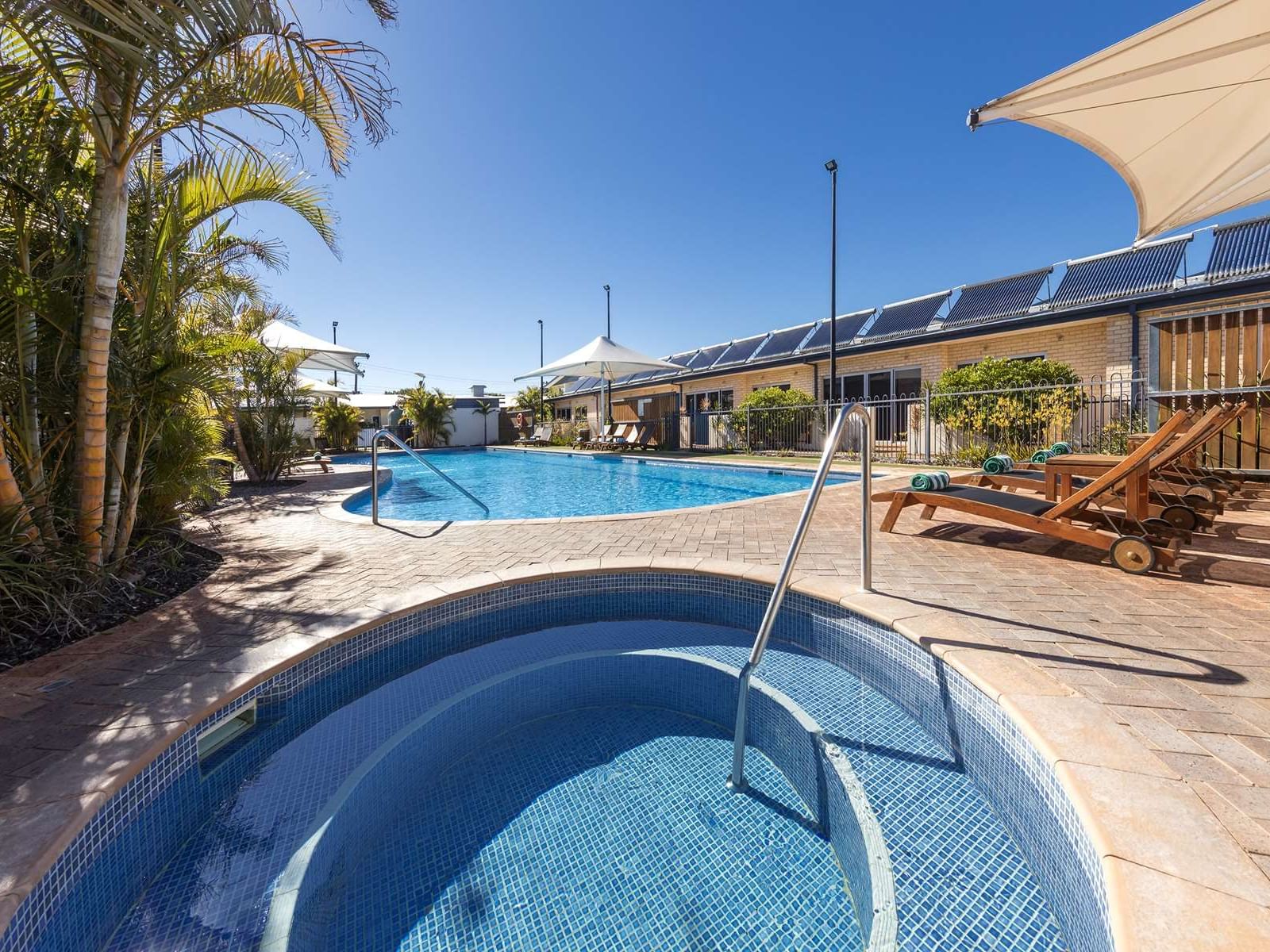 Sunbeds by the outdoor swimming pool area at Nesuto Hotels