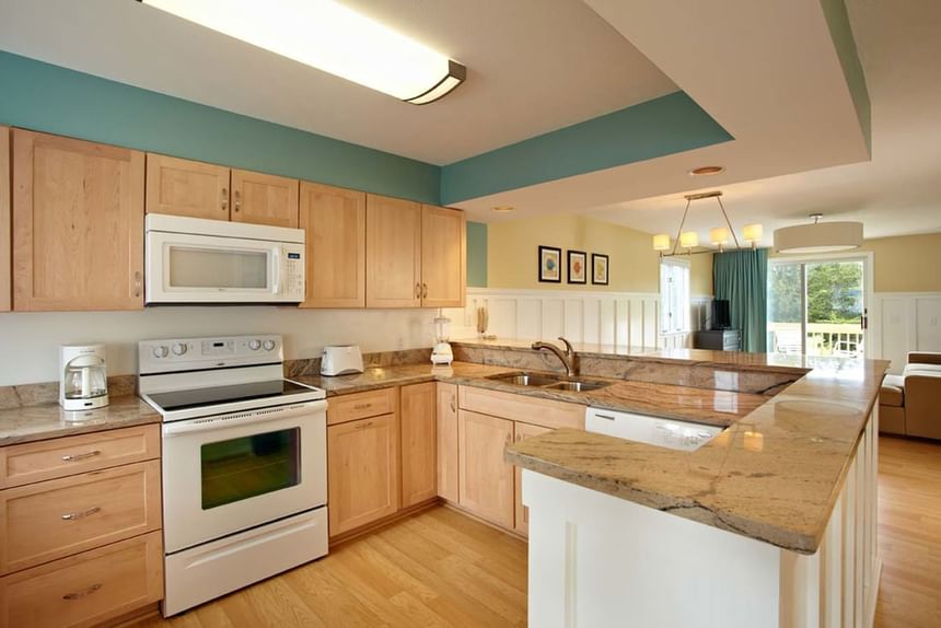 Kitchen with wooden cabinets and stainless-steel appliances in Nick Cottage at Breezeway Boutique Hotel