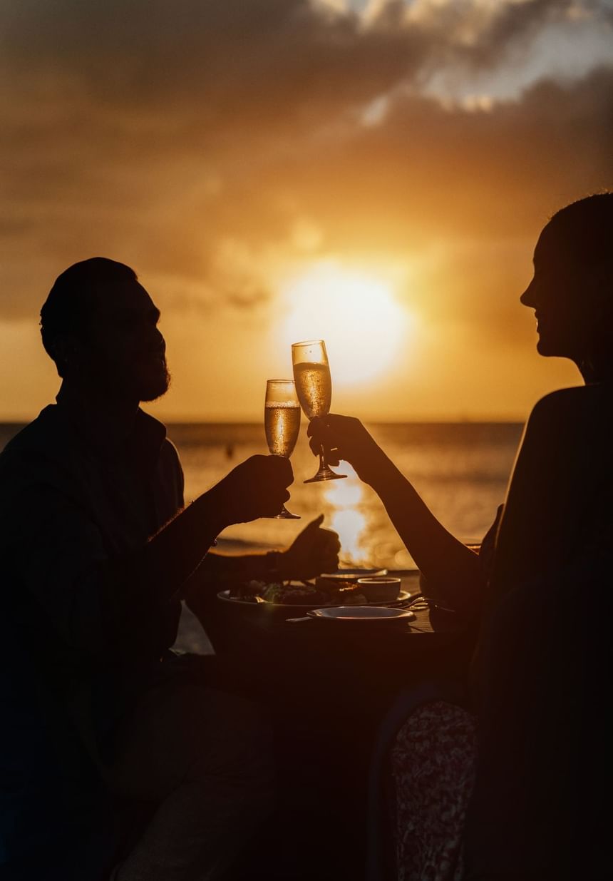 Romantic couple toastingduring sunset at Passions on teh Beach at Eagle Beach