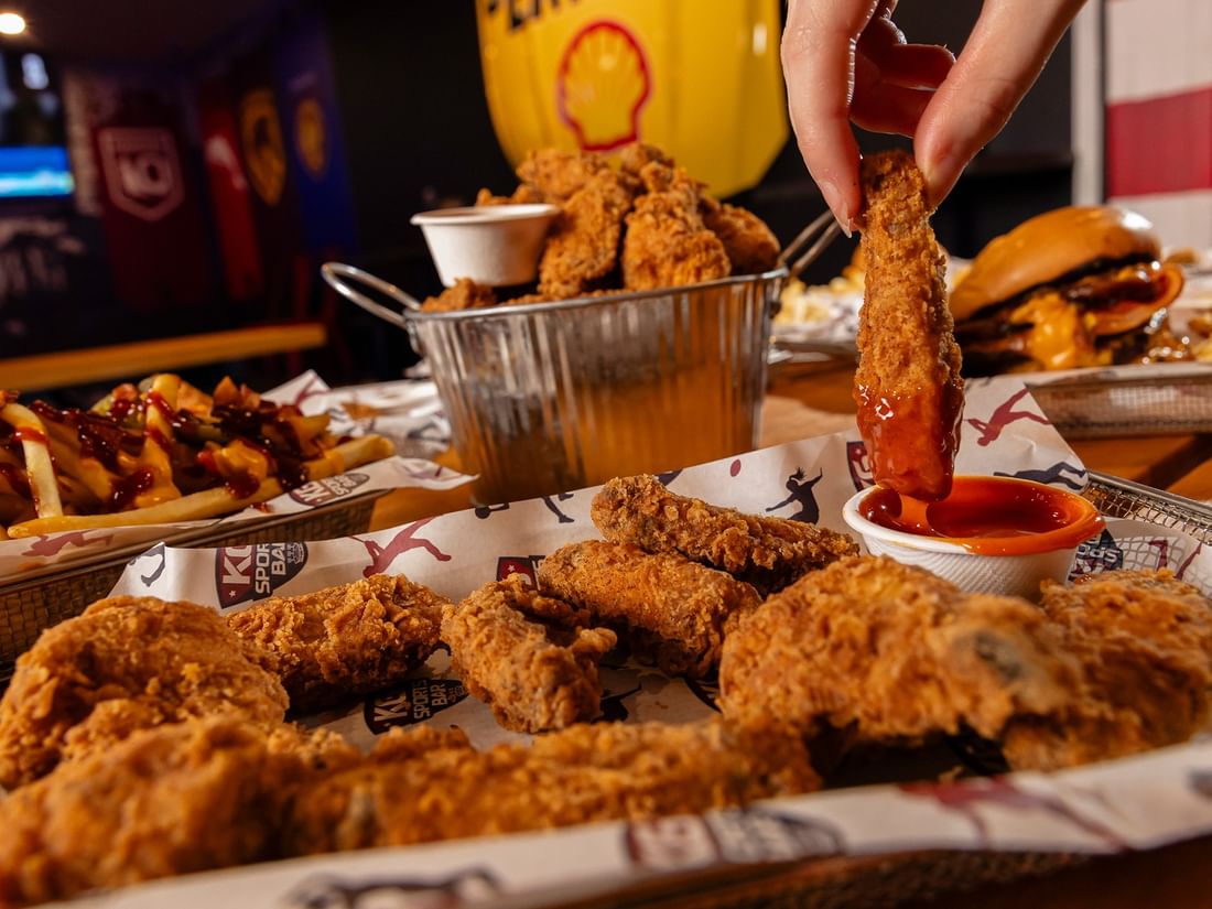Golden fried chicken wings served in a basket with sauce in KG Sport Bar at Mercure Brisbane King George Square