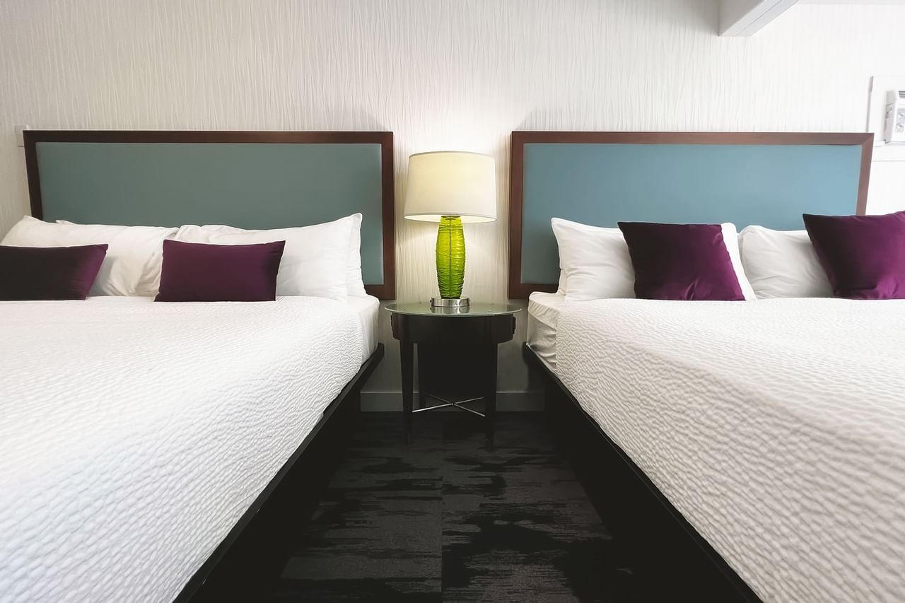 Guest room with two king beds, pillows, lamp