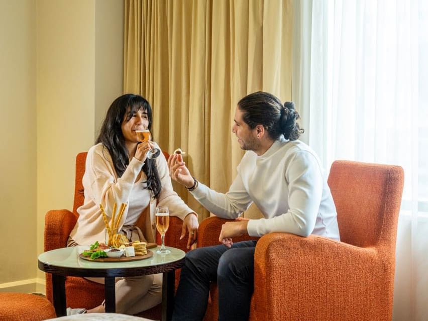 Couple enjoying Lucious snacks & champagne on a lounge at Hotel Grand Chancellor