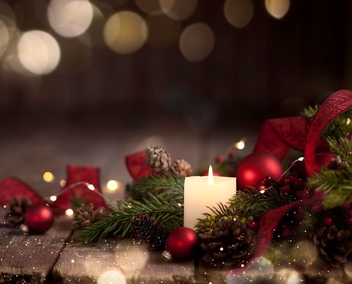Nahaufnahme eines Weihnachtskerzen-Geschenkkorbs, verziert mit goldenen Glitzerelementen, in festlicher Kulisse im „The Londoner Hotel“