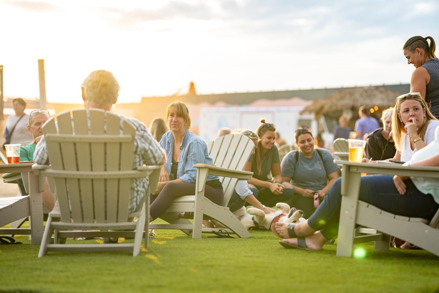 People lounging in the Beer Garden on a sunny day near The Artisan Hotel at Tuscan Village