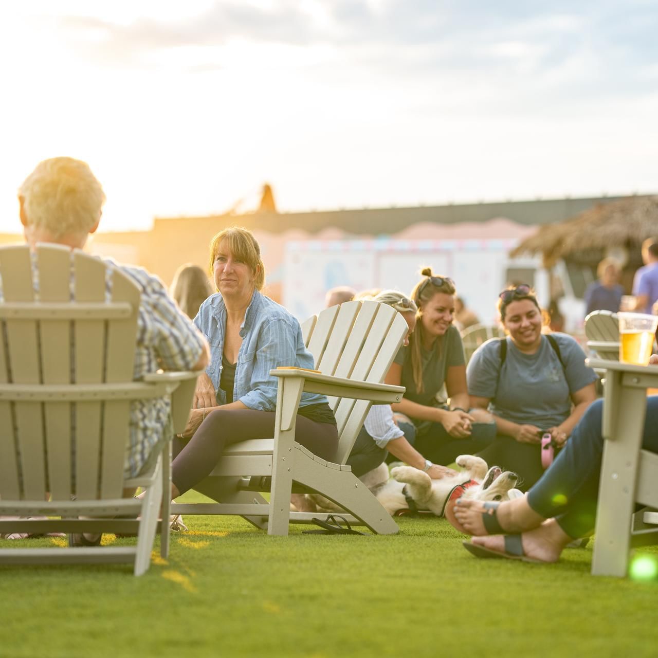People lounging in the Beer Garden on a sunny day near The Artisan Hotel at Tuscan Village